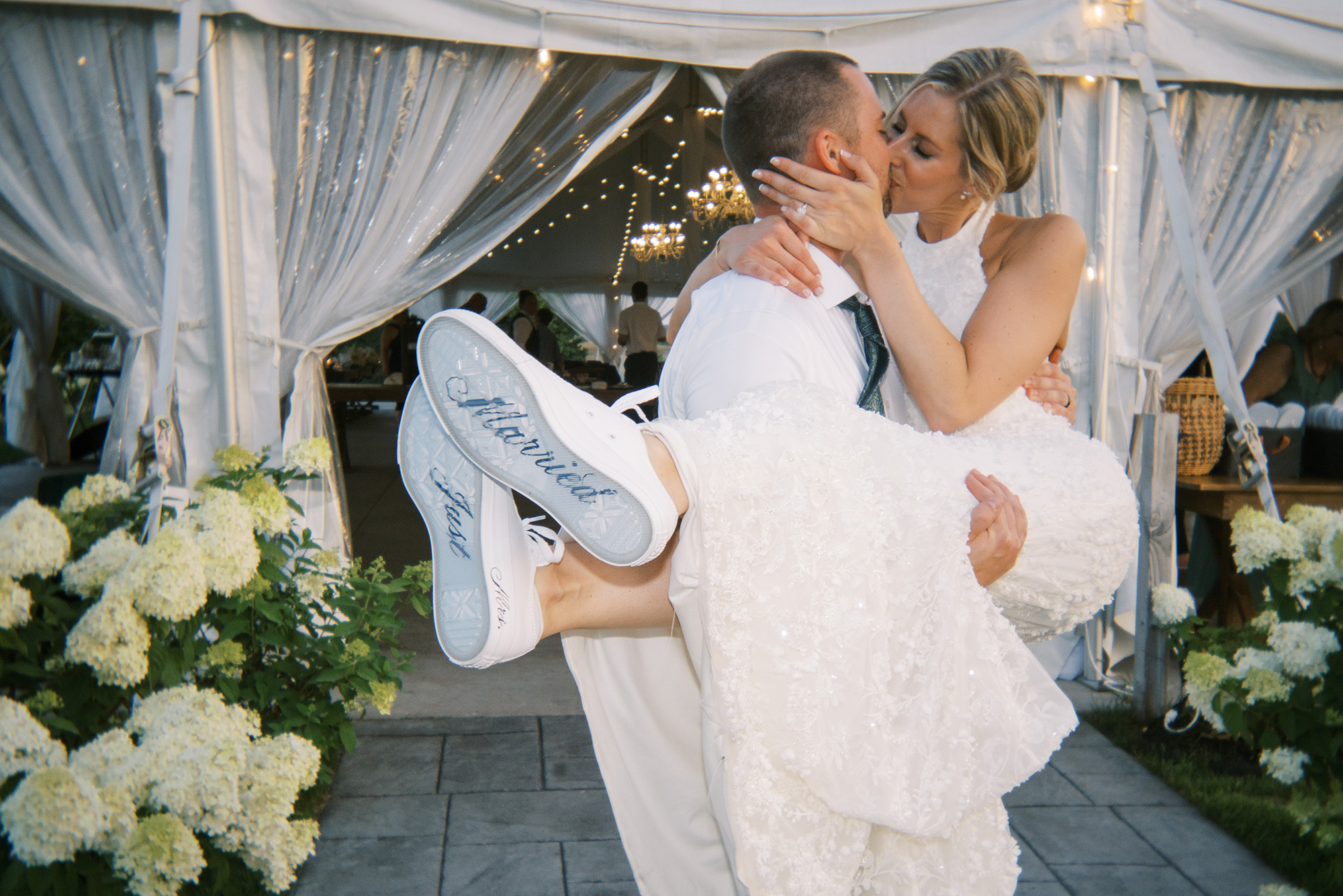 jen and josh kissing in front of tent at bay view weddings